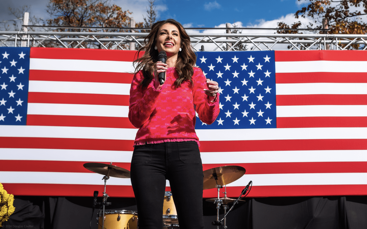 Morgan Ortagus On Stage, American Flags Backdrop